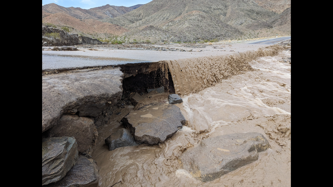 Floodwaters spill across the road, destroying pavement in Death Valley.