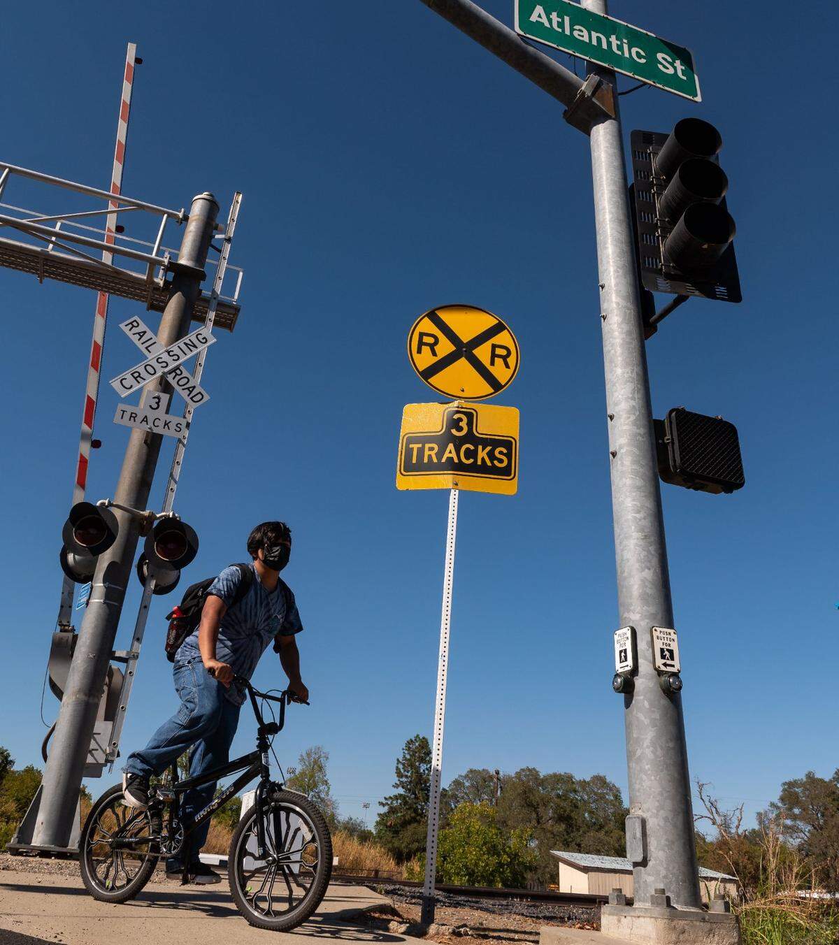 A Roseville High student bicycles across the railroad tracks along Atlantic Avenue at Tiger Way after school on Sept. 29.