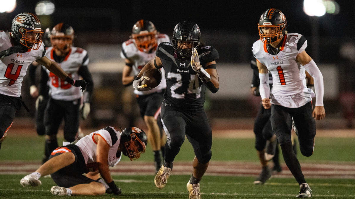 Woodcreek Timberwolves running back Hakeem Anderson breaks through the Roseville Tigers defense for a 54-yard touchdown in the first quarter on Friday at Woodcreek High School in Roseville.