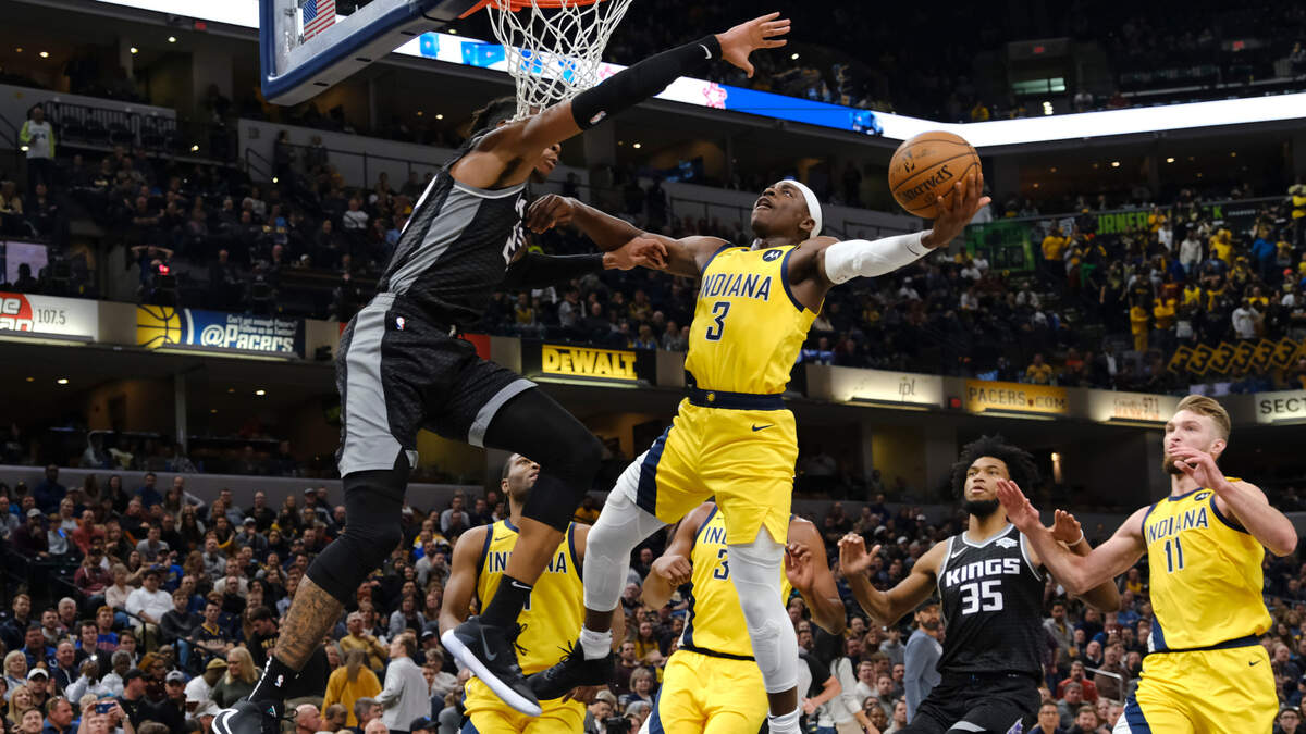 Indiana Pacers guard Aaron Holiday (3) shoots around Sacramento Kings forward Richaun Holmes (22) during the second half of an NBA basketball game in Indianapolis, Friday, Dec. 20, 2019. The Pacers won 119-105. (AP Photo/AJ Mast)