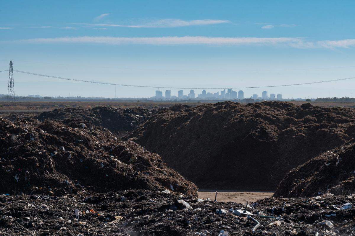 The Sacramento skyline stands in the distance as piles of organic waste are processed at the Yolo County Central Landfill in September 2022. 