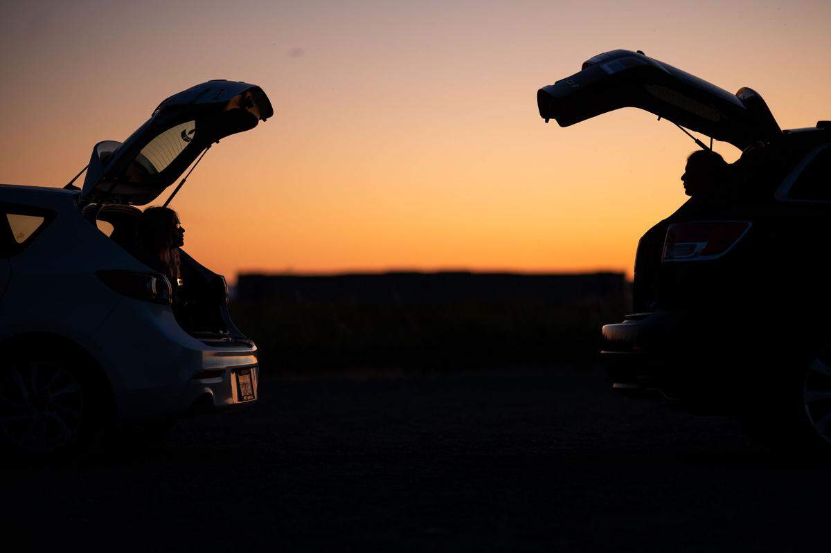 Madison Hood, left, of Yuba City, talks while about six feet away from Alyssa Watts, of Arden, while the two meet up in a remote gravel lot off West Elverta Road on Friday, May 22, 2020, in Sacramento County. They were roommates at Sonoma State until campuses were closed.