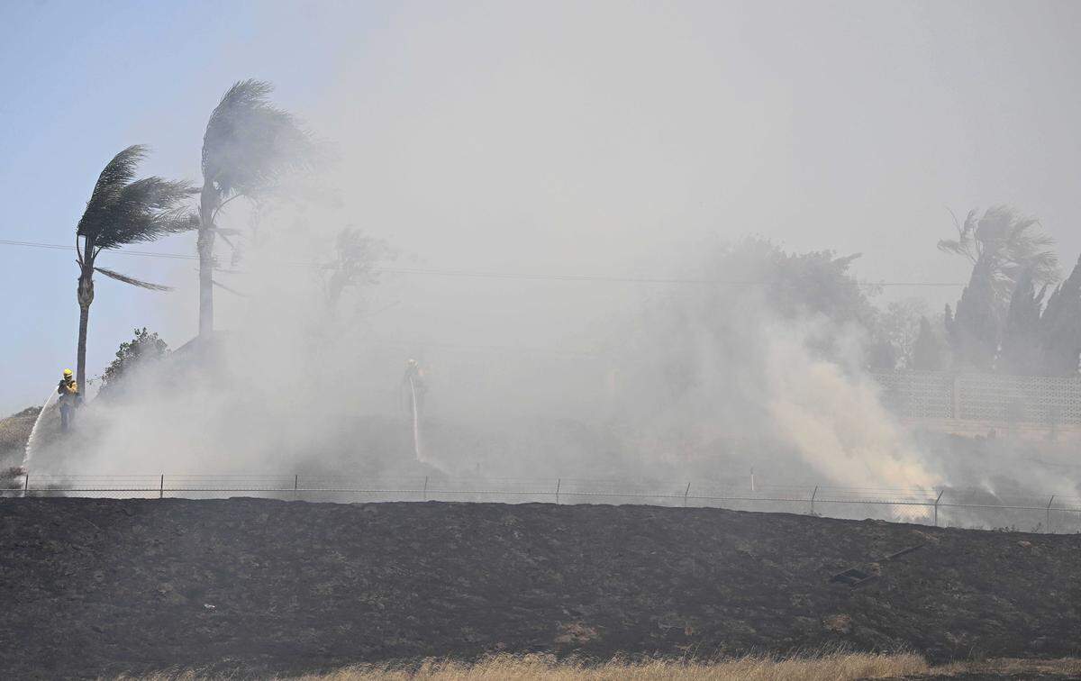 Firefighters work to save a home in strong winds as the Bain Fire burns in Riverside on Tuesday, May 19, 2026. The blaze is among several fires burning in Southern California as state officials warn that record-low snowpack and expanding drought could intensify this summer’s wildfire season in the north state.