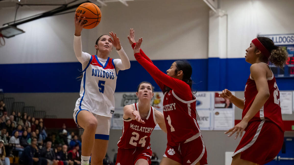 Folsom Bulldogs guard Ella Uriarte (5) drives past the McClatchy Lions’ Daisy Throckmorton for a layup in the third quarter in a CIF Sac-Joaquin Section girls basketball semifinal on Monday, Feb. 19, 2024, in Folsom.