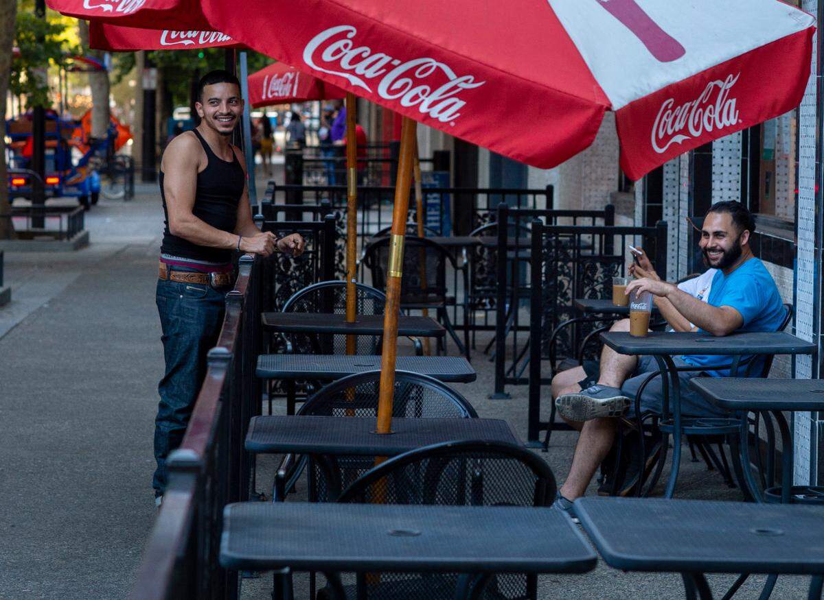 Yazan Barham, left, an artist with Freedom Unlocked takes a smoke break with neighboring business merchants from Holy Slice on K Street near 9th Street on June 5 as nightlife returns to downtown Sacramento.