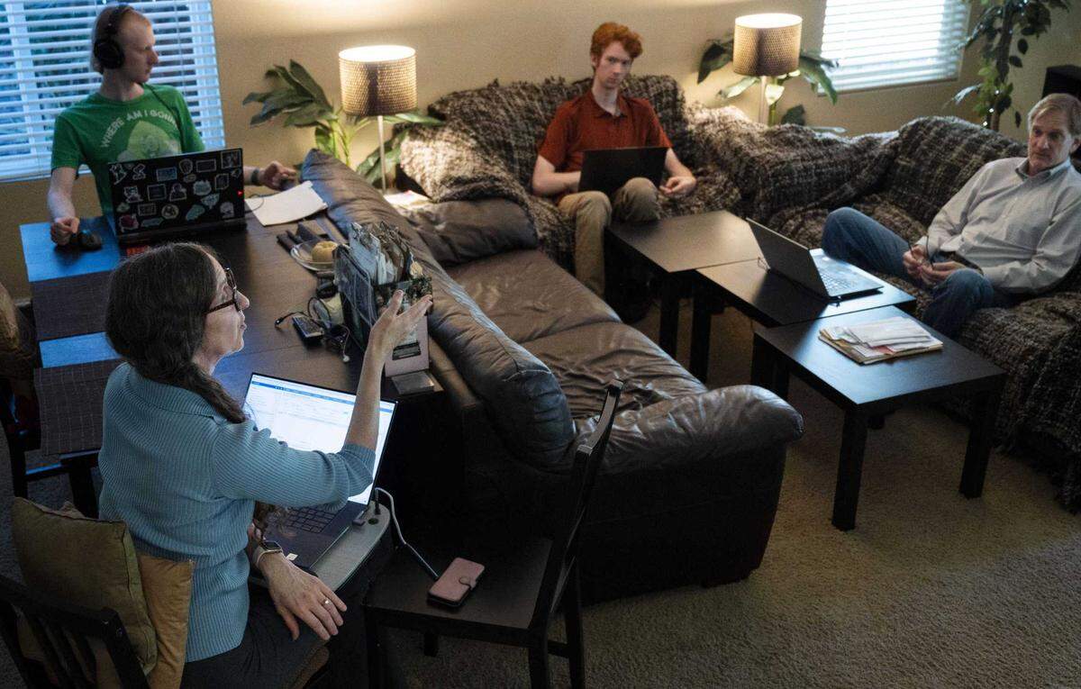 Sacramento attorney Tiffany Clark, left, talks to her husband Patrick, right, and sons, Elliot, center, and Keegan, in their living room in Natomas on Oct. 4, 2023, where they often all sit together on their laptops and work on their home businesses.