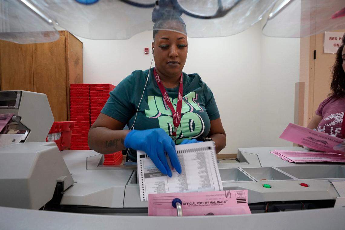 Election worker Antoinette Heckard removes a mail-in ballot from an envelope for the primary election at the Sacramento County Registrar of Voters in Sacramento on June 3.