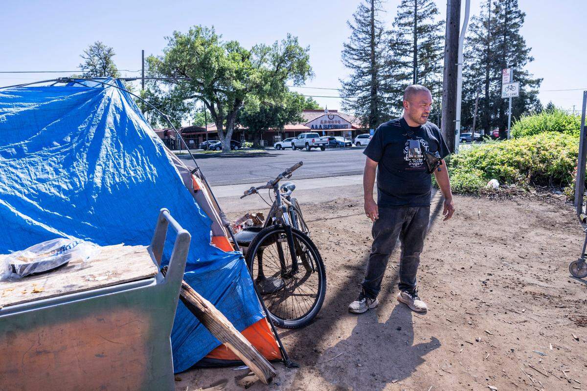Andy, a homeless man living on Stockton Boulevard, keeps an eye on his dog on Monday, April 21, 2025, after a nearby press conference in support of Assembly Bill 1435. The bill would create a tax credit, allowing businesses to deduct expenses for cleaning up encampments and illegal dumping. Andy, who said he’s been living on the street for more than five years, said he understands the business owners but wishes he could find housing as he waits his turn on a waiting list.