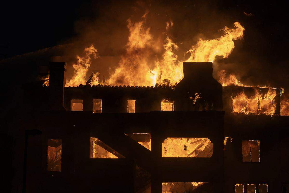 Firefighters attempt to extinguish a fire in a home along the Pacific Coast Highway in the Pacific Palisades neighborhood on Jan. 8, 2025.