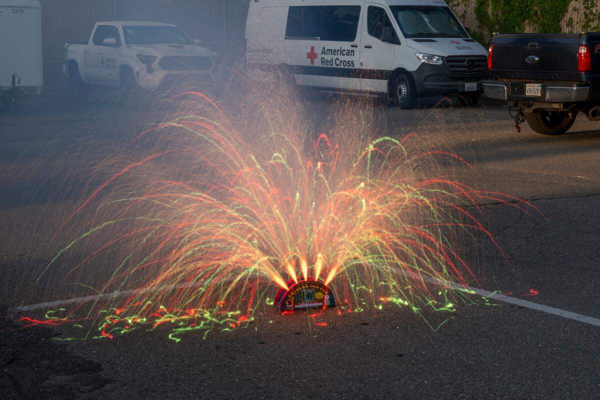 Phantom Fireworks’ Peacock Tail Fountain spews red lights in the parking lot of Sacramento Fire Department Station 19 on Thursday, June 19. The box emits three, and then five, pyrotechnic jets.