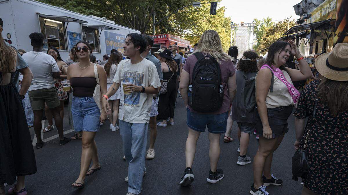 People order from food trucks in Sacramento in September 2025.  Sreet vendors are required to have a health and business permit.