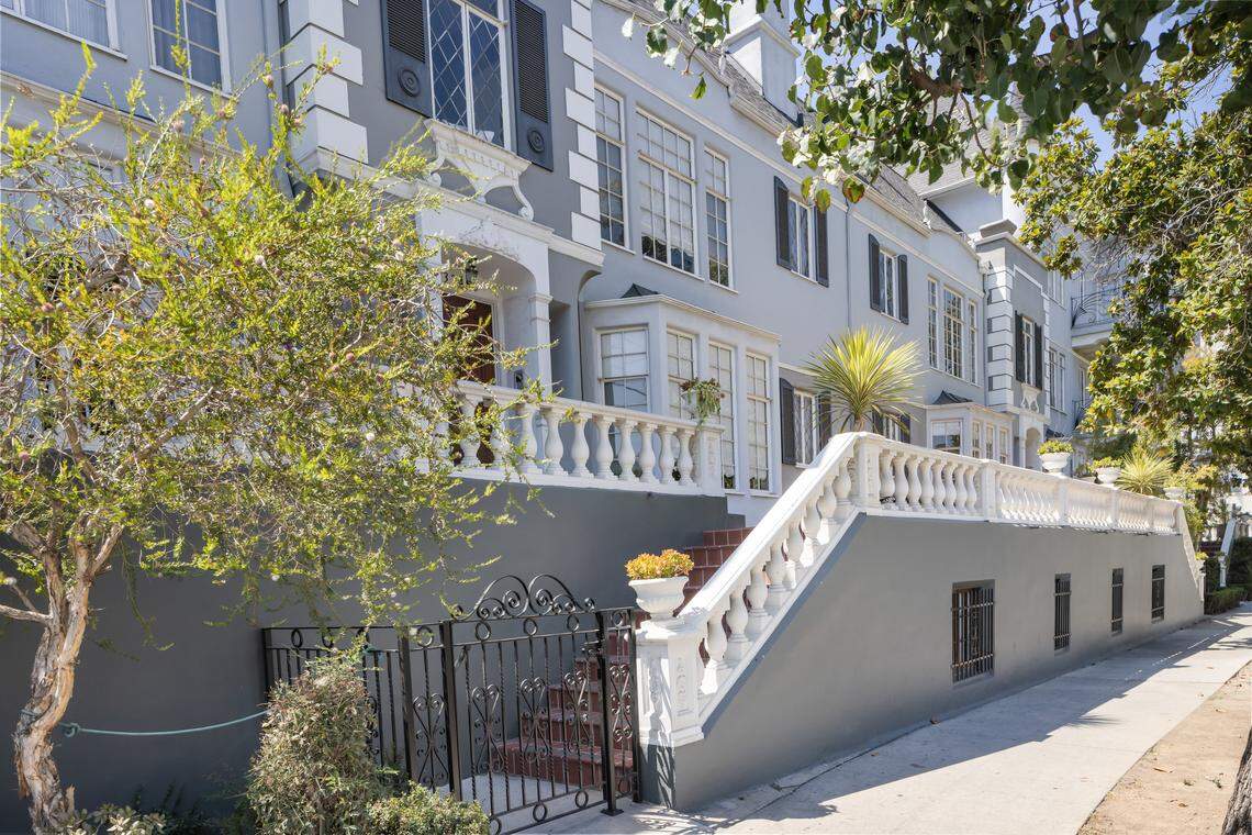 A sun-filled living room at this 1930s French Chateau-style condo captures stunning treetop views in Koreatown.