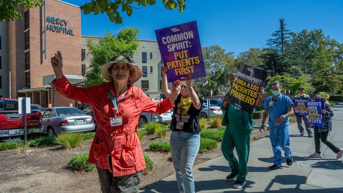 Common Spirit healthcare worker Cheri Nelson, 65, joins picketers outside Dignity Health Mercy General Hospital in Sacramento on Thursday in response to the outsourcing of critical jobs, layoffs and the impact on patient care. “As a conscientious worker I try to do everything they throw at me and it’s very stressful,” Nelson said.