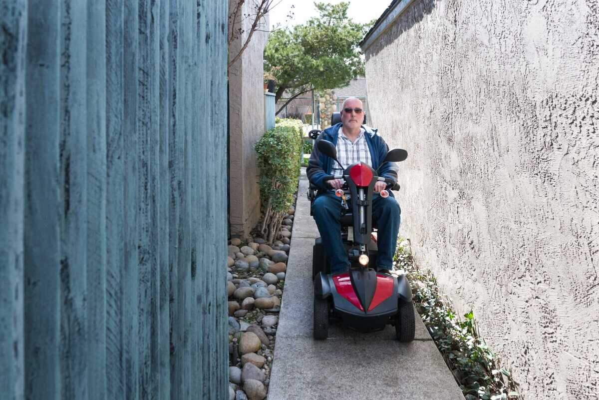 Lloyd Tennison, a Medi-Cal enrollee, drives his motorized scooter through his apartment complex in Stockton.