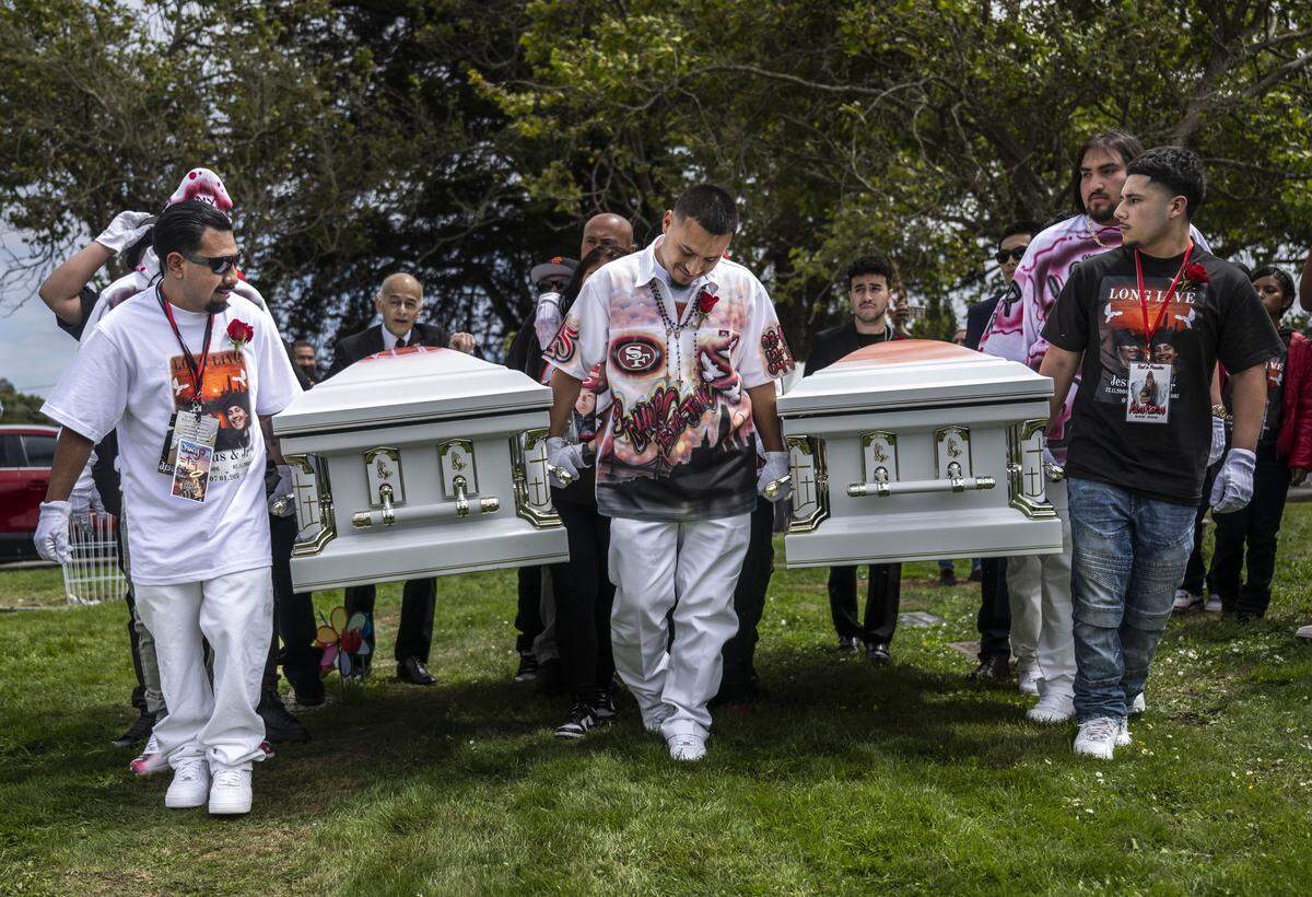 Ernesto Ramos, center, whose younger brothers Jesus and Jhony Ramos were killed in the Esparto fireworks explosion, holds their caskets during their burial service at Greenlawn Memorial Park in Colma on Monday, July 28, 2025. “They were my kids,” said Ernesto during the wake.
