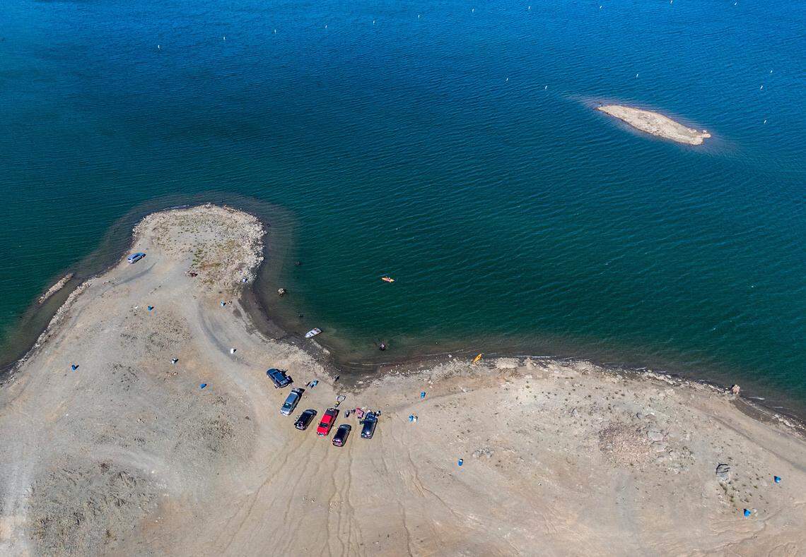 The vehicles of boaters and kayakers cluster at the diminished shoreline of Folsom Lake near the Brown’s Ravine boat ramp on Tuesday, June 8, 2021. The lake currently holds 43% of the normal amount of water for this time of year.