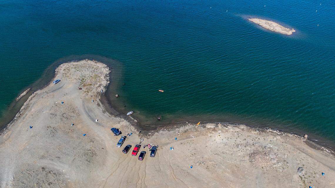 The vehicles of boaters and kayakers cluster at the diminished shoreline of Folsom Lake near the Brown’s Ravine boat ramp on Tuesday, June 8, 2021. The lake currently holds 43% of the normal amount of water for this time of year.