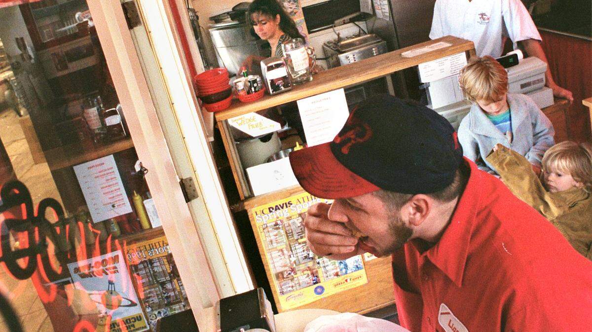 Regular customer Liam Riley eats his hot dog at the small counter in The Hotdogger, 129 E. Street, Davis.
