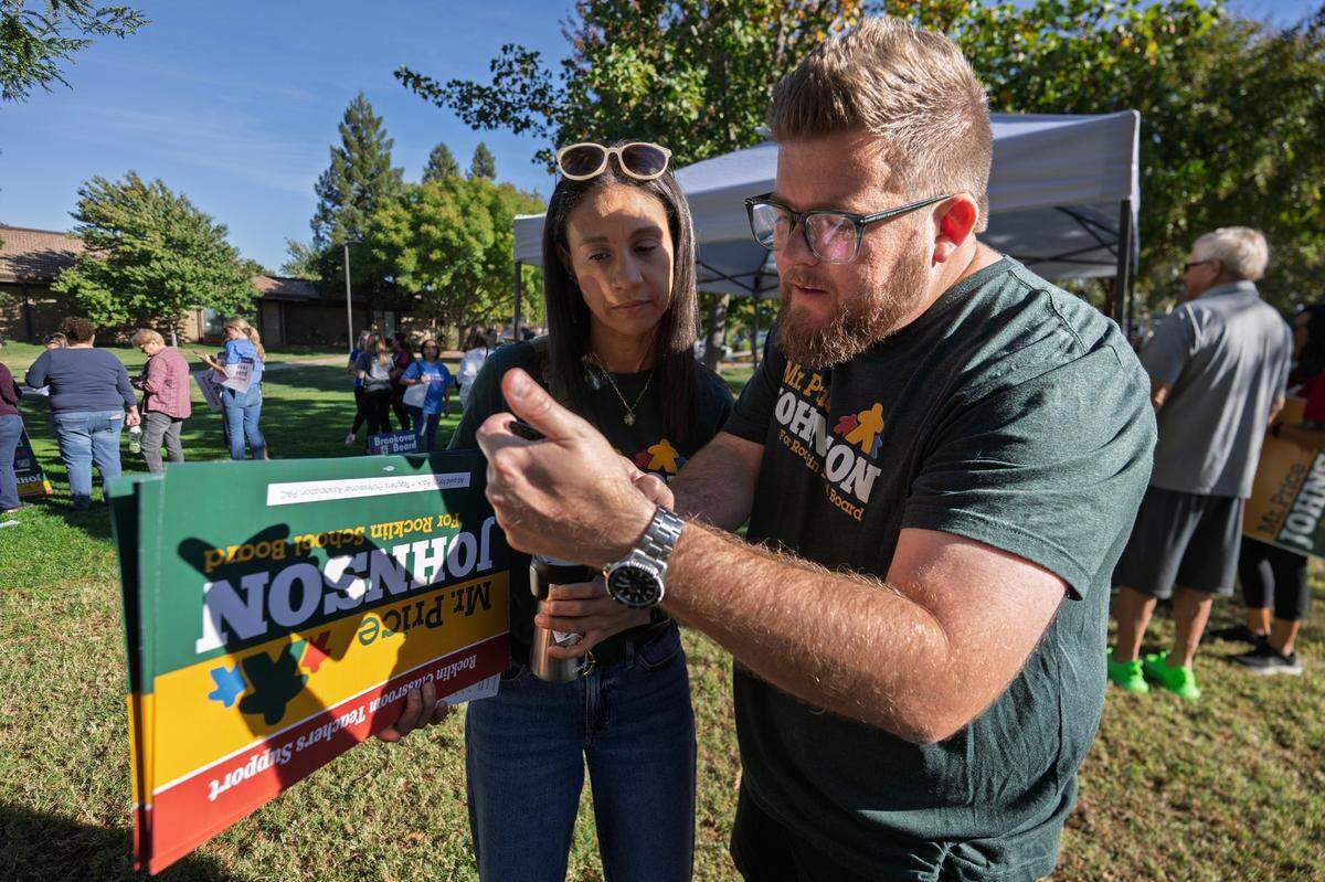 Price Johnson, a candidate for school board of the Rocklin Unified School District, and volunteer Nichole Moraru view a map of a Rocklin before canvasing the neighborhoods earlier this month.