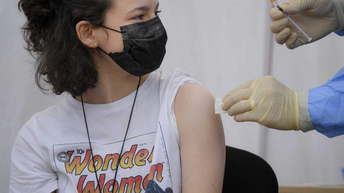 A teen gets a Pfizer BioNTech COVID-19 vaccine in June.