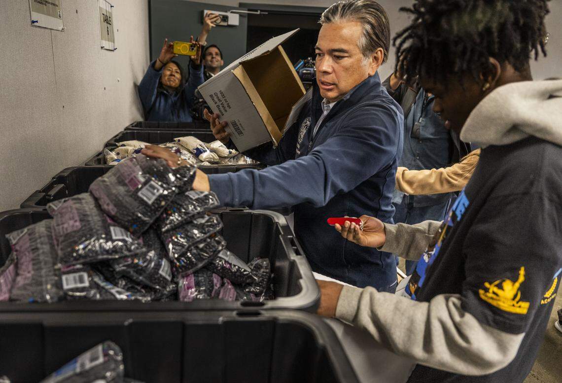 California Attorney General Rob Bonta helps organize food donations at Natomas High School with the help of student Amir Carter, who is a member of Improve Your Tomorrow, a program supported by AmeriCorps, on Tuesday.