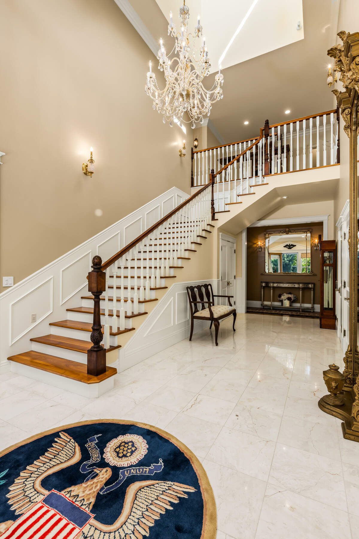 A dramatic entry pairs marble floors with a soaring cupola overhead and a solid-walnut staircase that showcases the home’s meticulous craftsmanship.