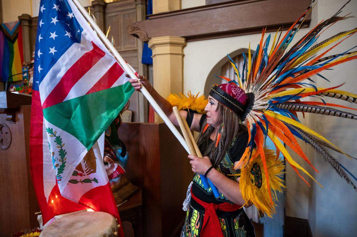 Sonia Martinez, a dancer with Danza Azteca Huitzitzilin Ollin, holds an American and Mexican flag during a recent Iglesia Luterana Santa María Peregrina church service in Stockton.