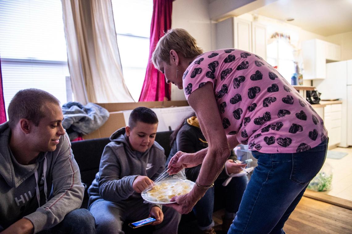 Landon Griffith, 11, gets a deviled egg from grandmother Susie Hammond, as his uncle Cameron Scism sits next to him on Thanksgiving Day, Nov. 22, 2018.