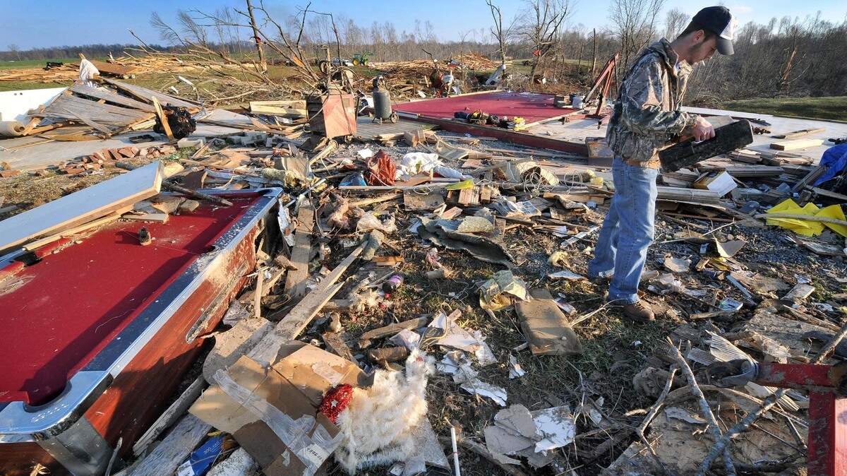 Timothy Stinson, brother to Felicia Stephens who lived in one of the mobile homes that was hit by the tornado, tries to salvage anything he can find for his family Thursday, Feb. 7, 2008 in Holland, Ky. His two-year-old nephew, Hunter, was killed not far from where they found his sister after the storms in Allen County Tuesday night killing four people.