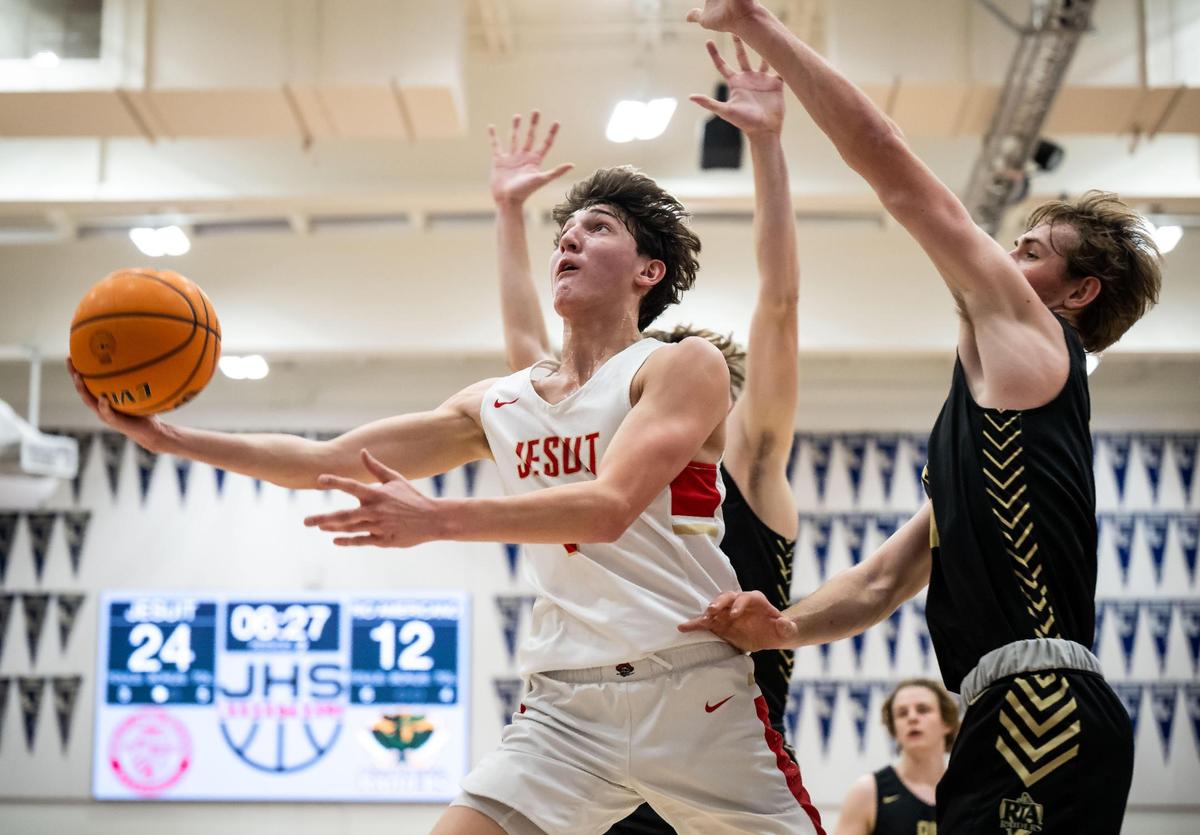 Jesuit Marauder guard Reid Jones (1) goes up for a layup asRio Americano Raider guard Luke Mason (11) defends during the first half of the high school boys basketball game Friday, Dec. 16, 2022, at Jesuit High School in Carmichael.