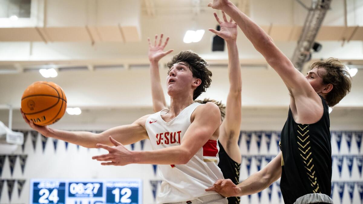 Jesuit Marauder guard Reid Jones (1) goes up for a layup as Rio Americano Raider guard Luke Mason (11) defends on Dec. 16, 2022.