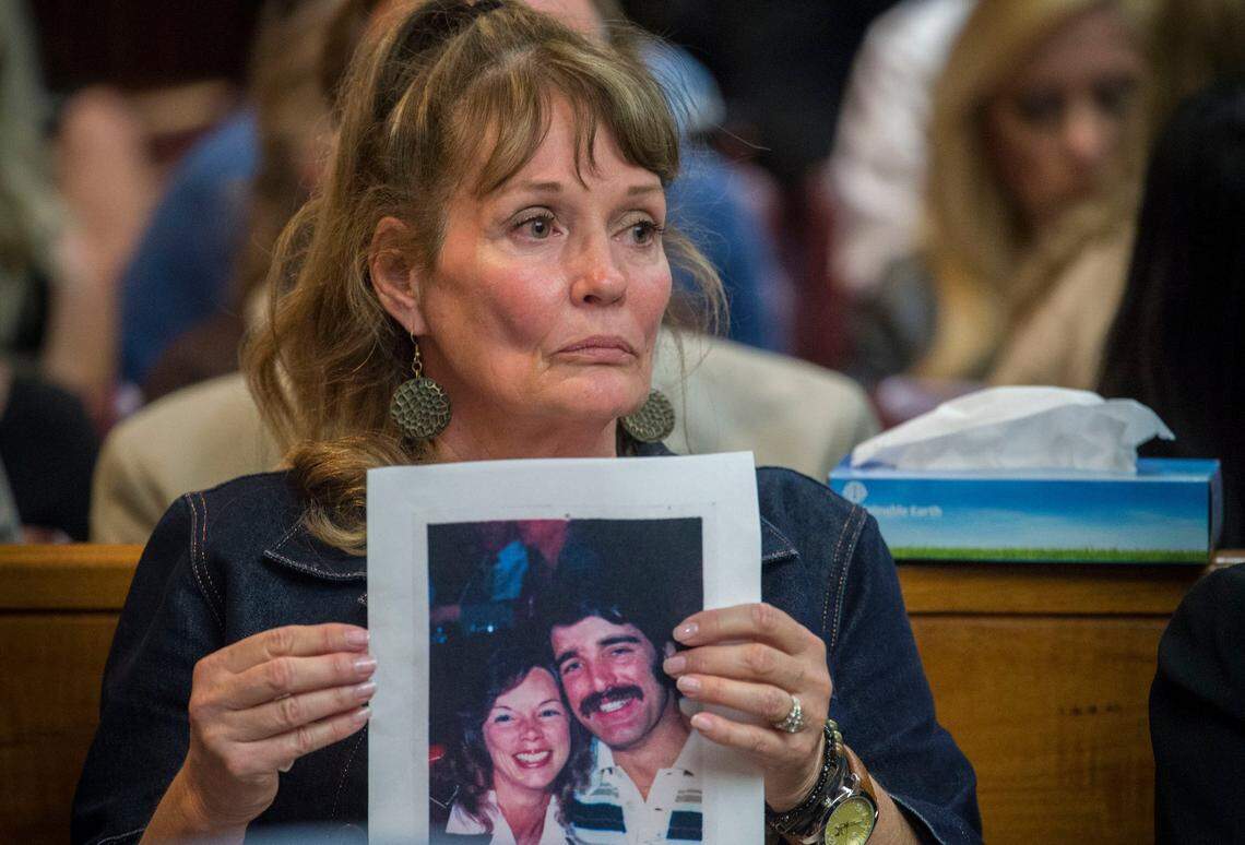 Melanie Barbeau holds a photograph of victims Cheri Domingo and Greg Sanchez during the arraignment of Joseph James DeAngelo, the suspected East Area Rapist on Friday, April 27, 2018 in Sacramento. The couple is believed to have been killed by DeAngelo in 1981 in Goleta, Calif.