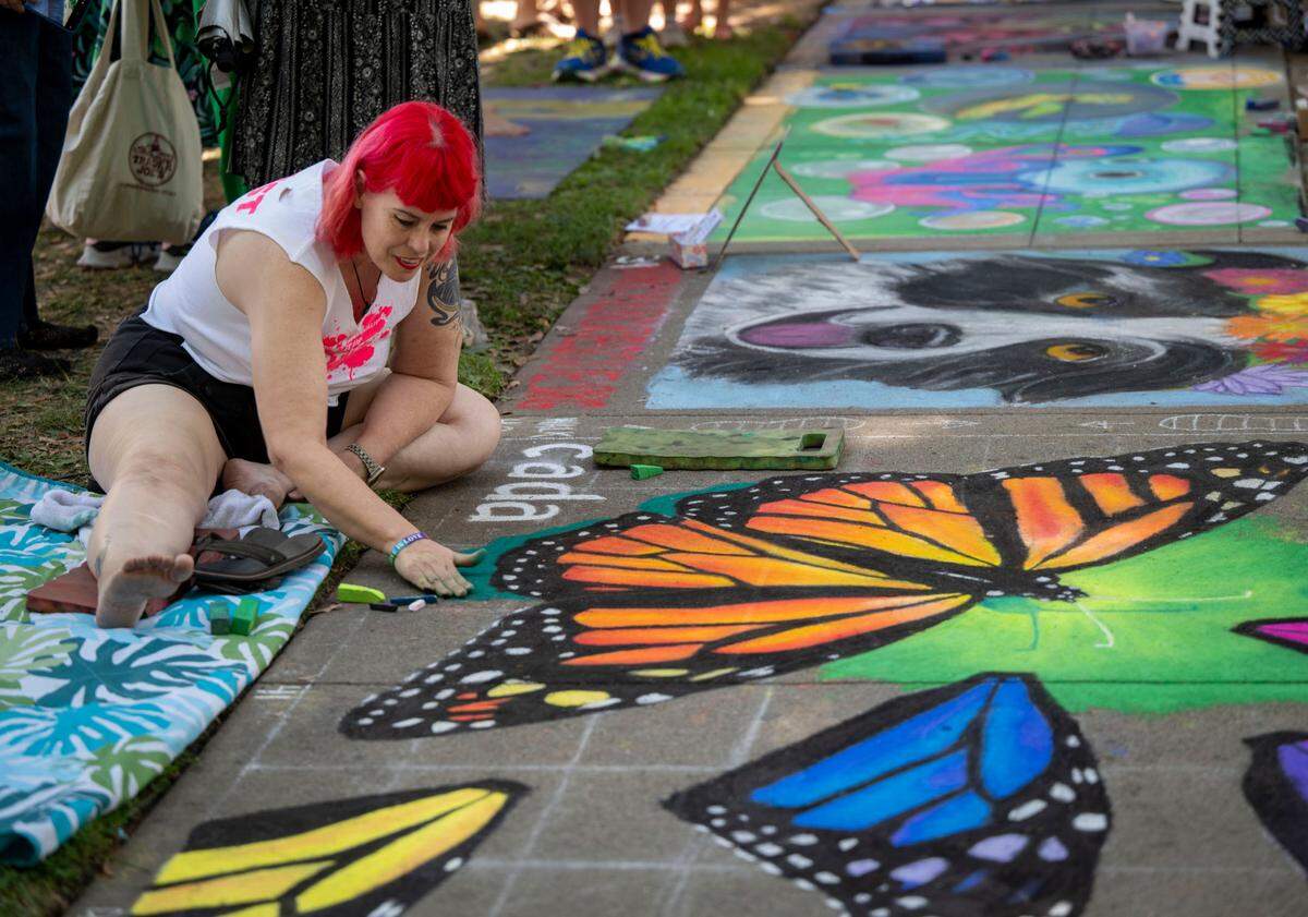 Dawn Pedersen, an artist from West Sacramento, works on her art piece of butterflies at the Chalk it Up festival on Sunday at Fremont Park.