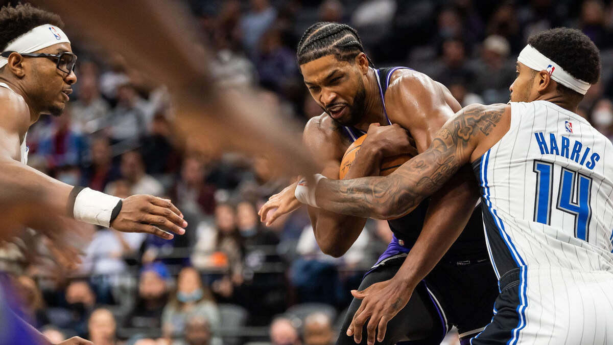 Sacramento Kings center Tristan Thompson (13) is fouled while on offense by Orlando Magic guard Gary Harris (14) during the fourth period at the NBA basketball game Wednesday, Dec. 8, 2021, at Golden 1 Center in Sacramento. The Kings beat the Magic 142-130.