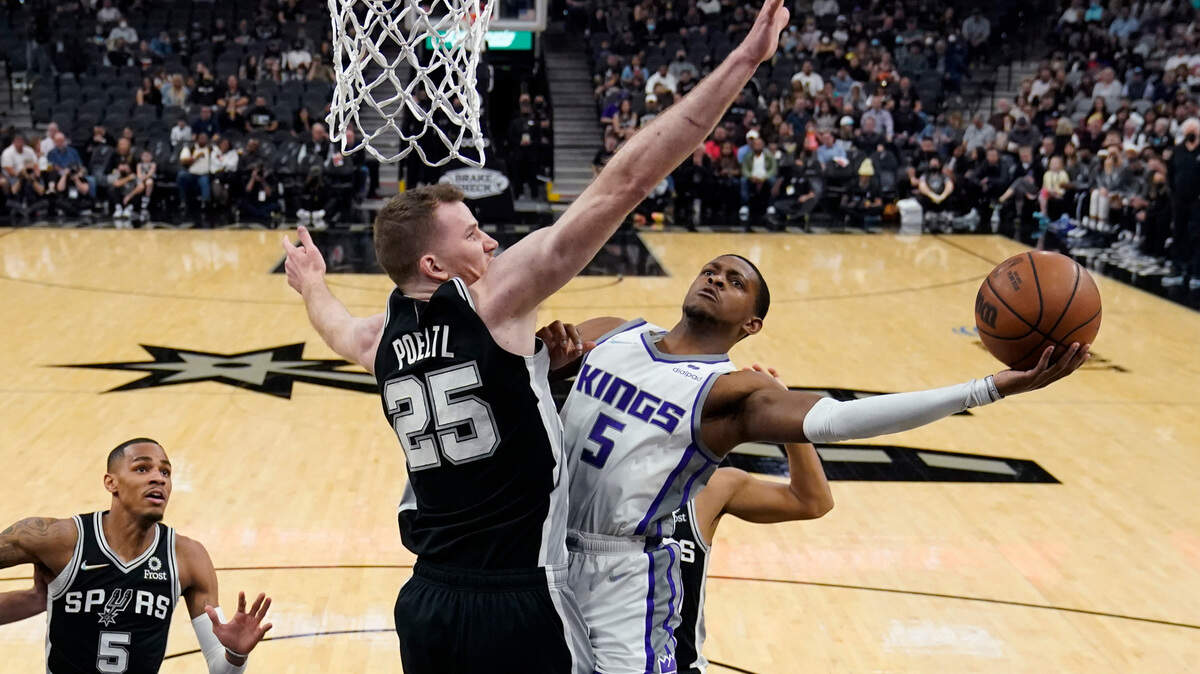 Sacramento Kings guard De’Aaron Fox (5) drives to the basket against San Antonio Spurs center Jakob Poeltl (25) during the first half of an NBA basketball game Thursday, March 3, 2022, in San Antonio. (AP Photo/Eric Gay)