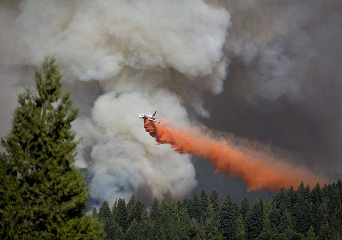 A jet drops a load of fire retardant near Highway 50 at the King Fire in El Dorado County near Pollack Pines on Monday, Sept. 15, 2014.
