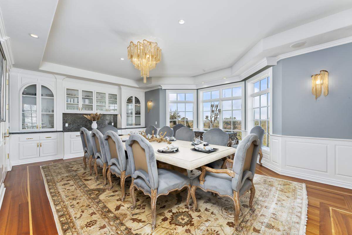 The formal dining room is large with panoramic views of the estate grounds. The doors can be closed for privacy.