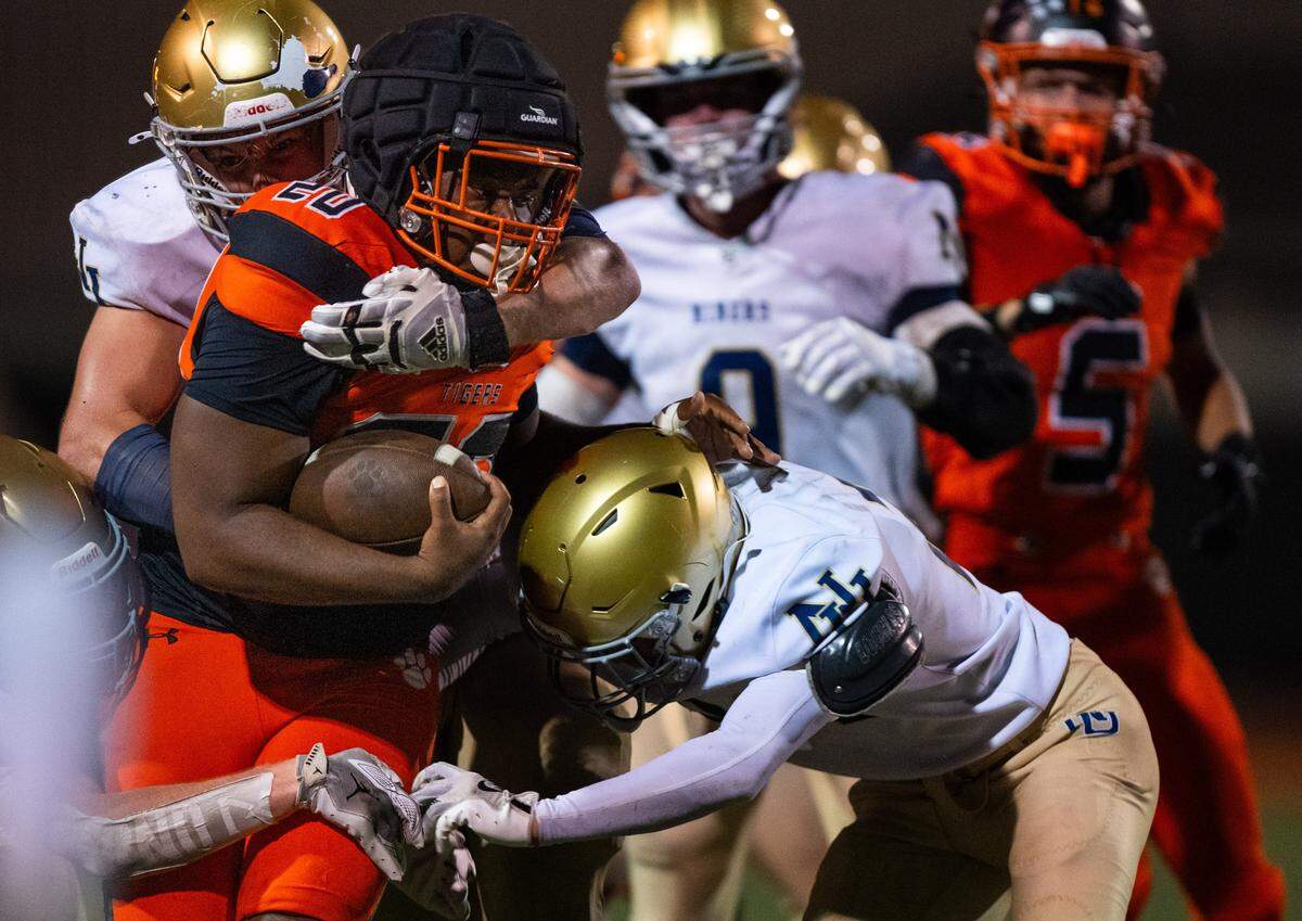 The Roseville Tigers’ D'marcis Gresham (20) rushes for a first down on a fourth a short against the Nevada Union Miners on Friday.