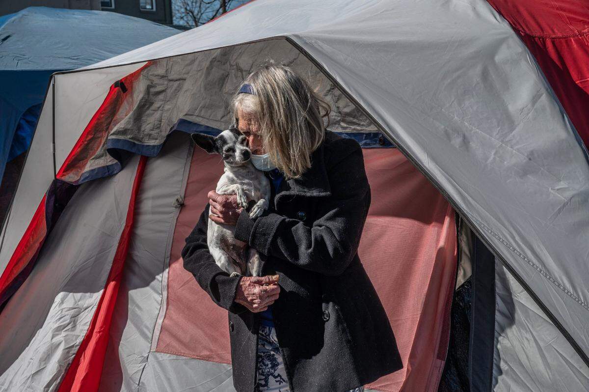 Deena Smith, 71, snuggles with her dog Molly in 2021 at the Safe Ground encampment at 12th and C streets in Sacramento’s Alkali Flat neighborhood. “This place – its wonderful. It saved my life.”