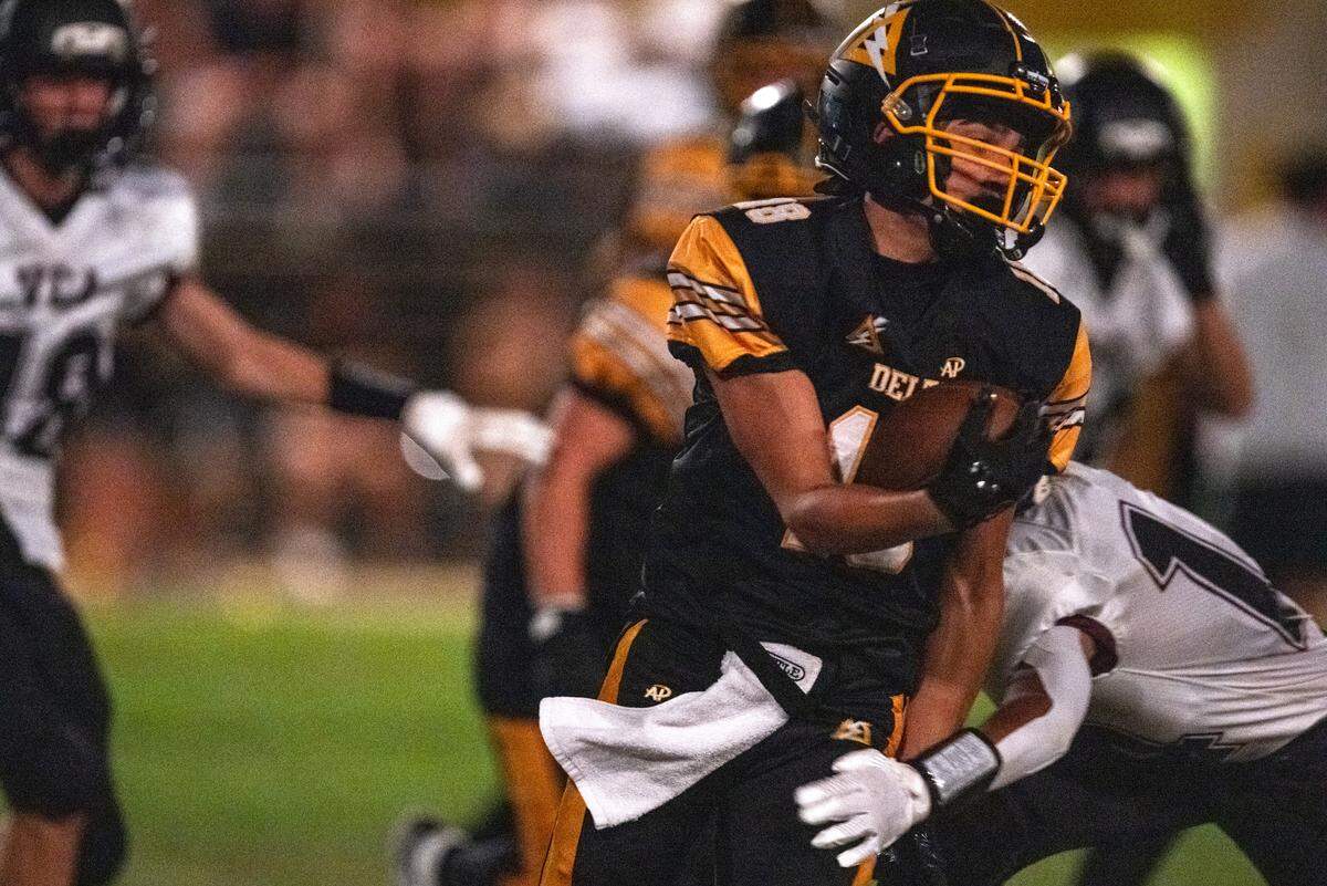 The Delta Saints' Marcello Viramontes (18) runs for a long gain against the Valley Christian Lions in the first half in an 8-man football game in Clarksburg on Friday.