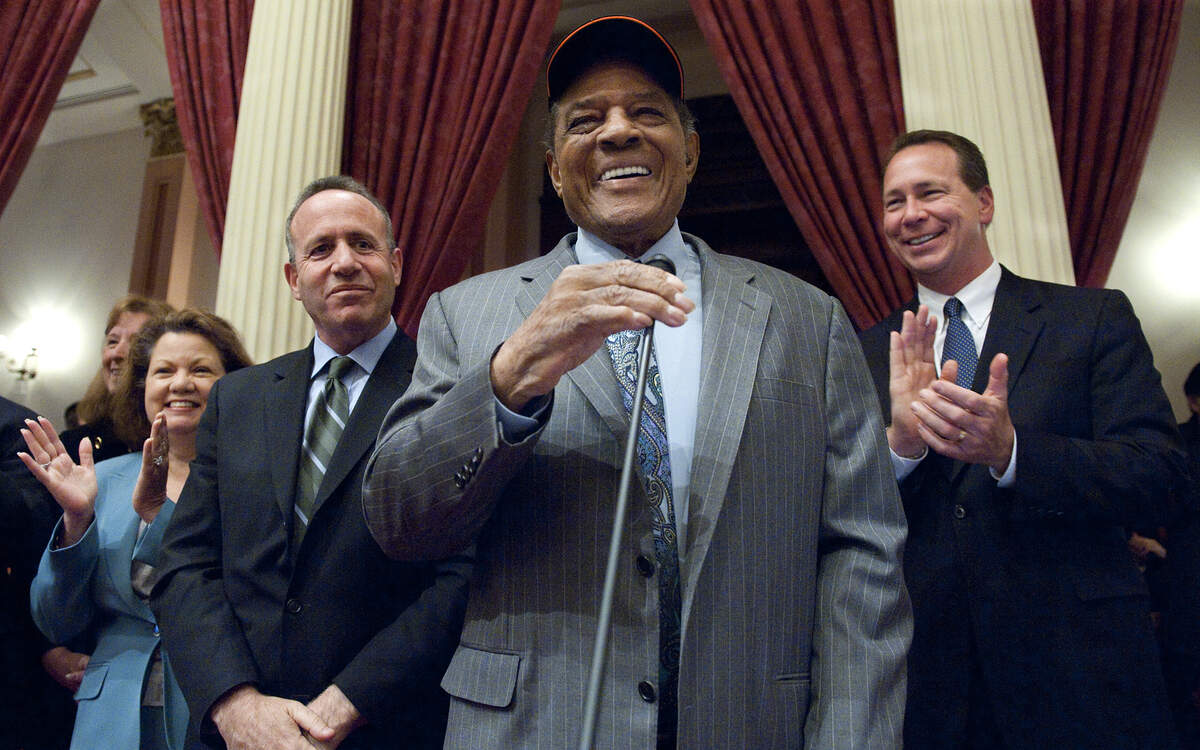 Willie Mays toma el micrófono mientras agradece a los senadores que le invitaran a Sacramento para la declaración del Día de Willie Mays en California en 2010. Detrás de él están el entonces presidente pro tem del Senado Darrell Steinberg, demócrata de Sacramento, y el entonces líder republicano del Senado Dennis Hollingsworth, republicano de Murrieta, a la derecha.