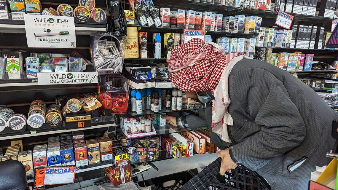 Owner of New City Plus smoke shop in Oakland, Rafiq Aldami, pulls flavored vape cartridges from his shelves in December as California’s ban on flavored tobacco products went into effect.
