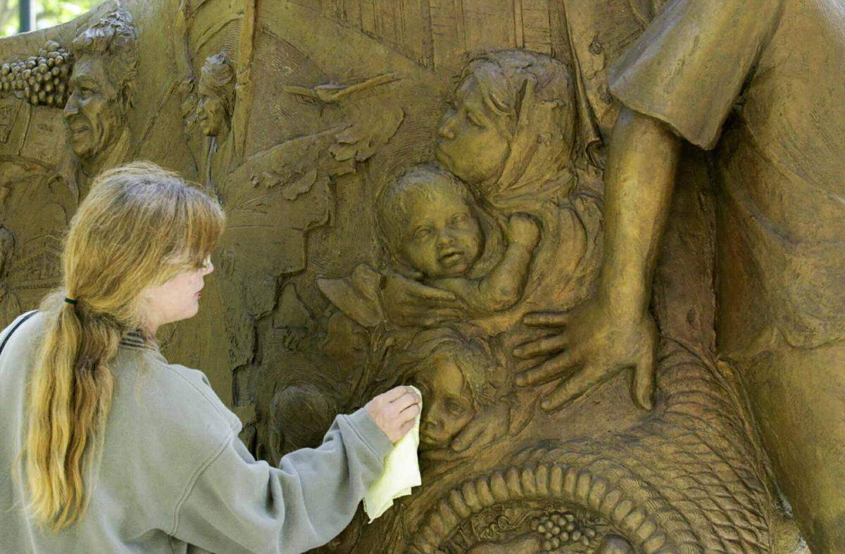 Lisa Reinertson, of Davis, applies wax in 2001 to the bronze sculpture that she created for the Cesar E. Chavez Plaza in downtown Sacramento. The statue depicts the Delano to Sacramento march in 1966, which Reinertson attended as a child.