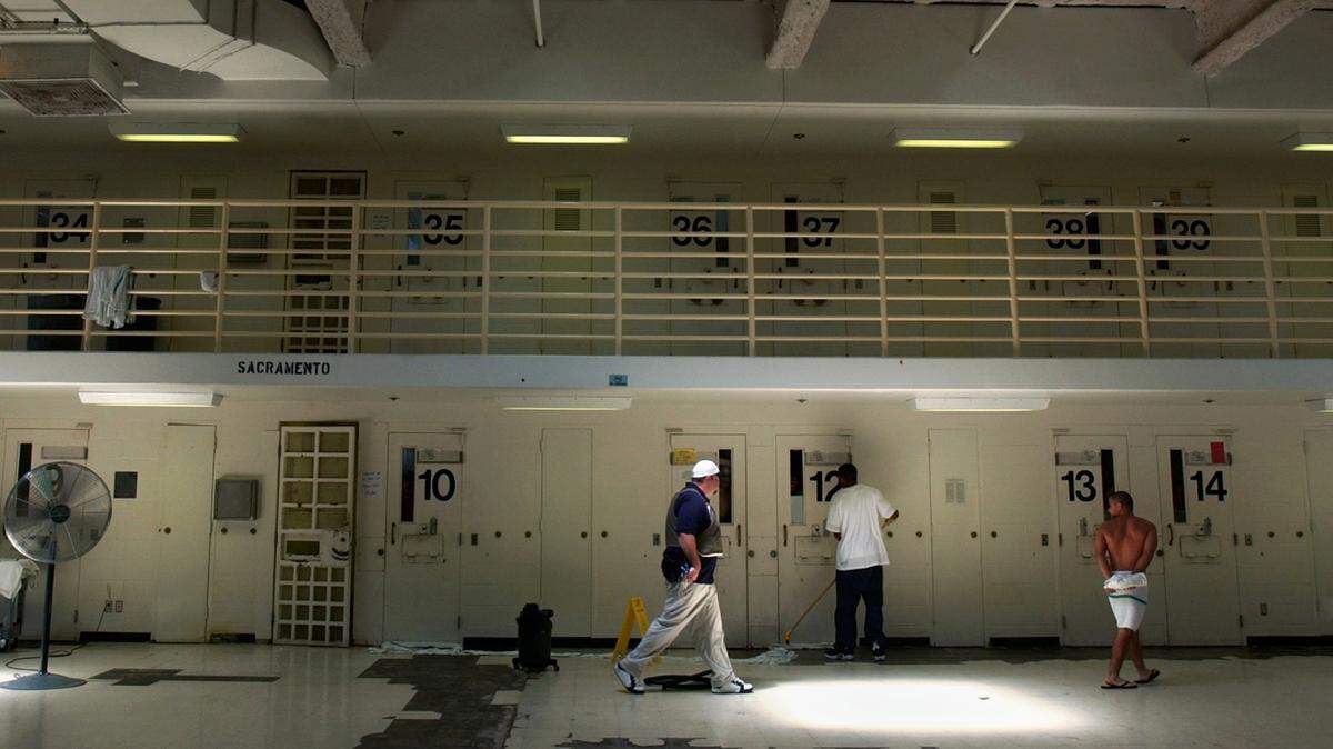 A correctional councelor escorts a ward to a shower while another does some cleaning in a cell block complex at the N. A. Chaderjian Youth Correctional Facility in Stockton in 2004. The facility will close this year.