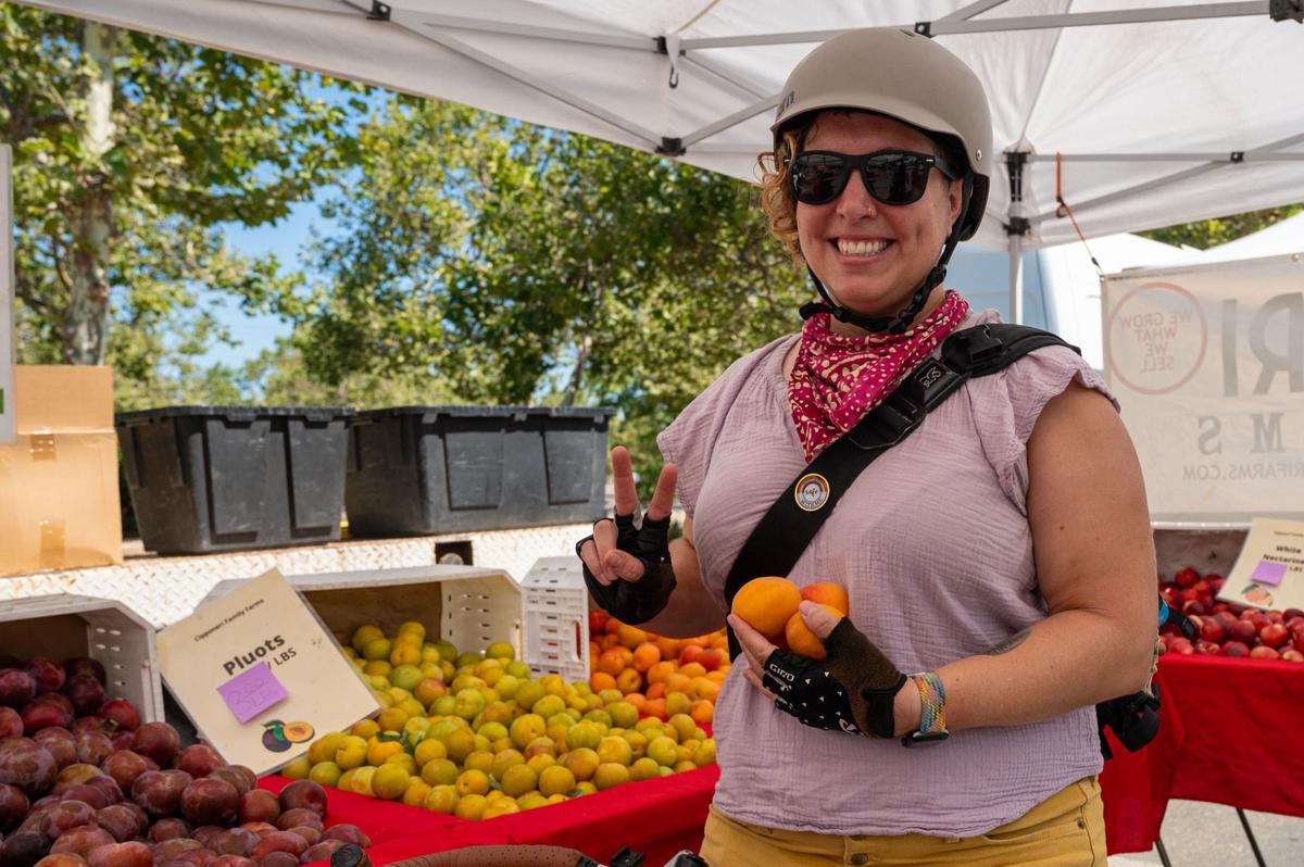 Sacramento Area Bicycle Advocates member Mira Cukrov purchases apricots from Cipponeri Family Farms at the Meadoview Farmers’ Market in Sacramento on June 23.