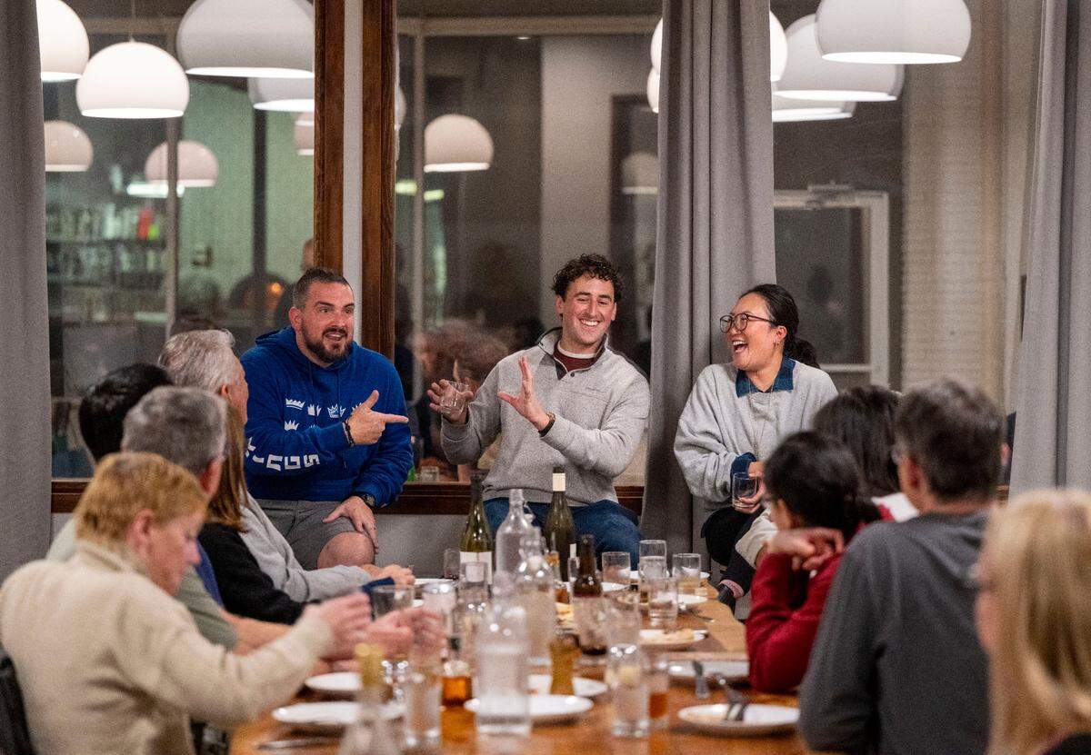 Localis chef Chris Barnum-Dann, left, and Binochoyaki chef chef Toki Sawada, right, laugh with Sacramento Bee reporter Benjy Egel, center, during a book signing event for Egel’s cookbook “Sacramento Eats” on Wednesday at Masullo restaurant in Land Park.