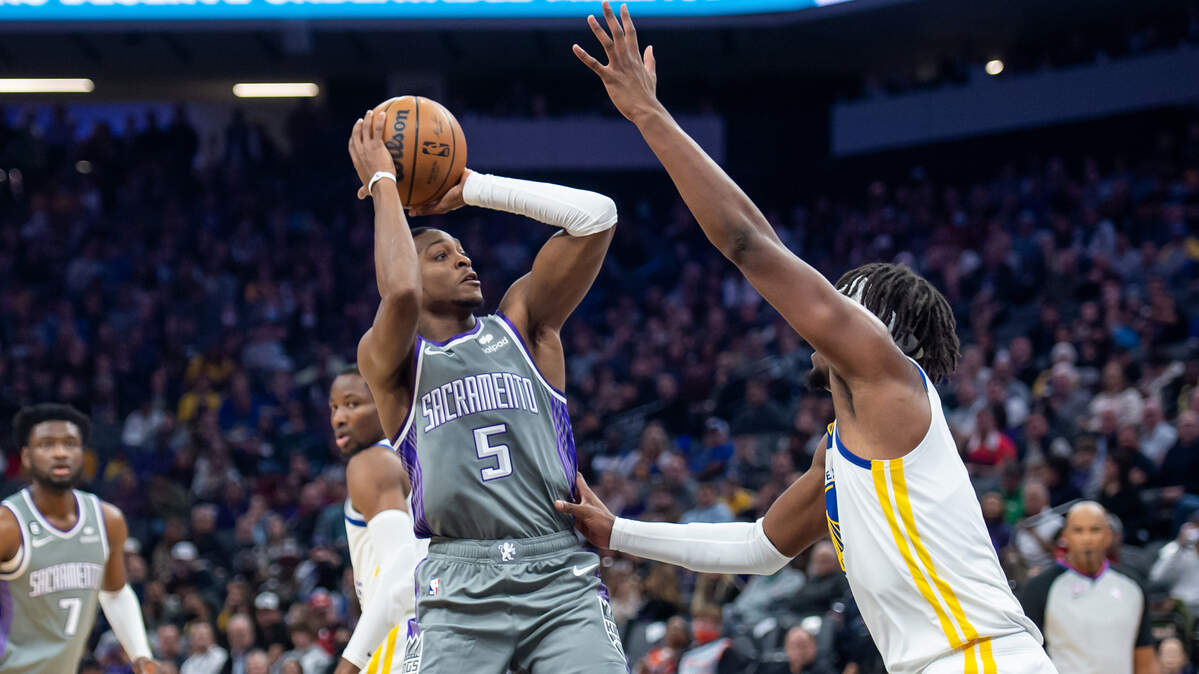 Sacramento Kings guard De’Aaron Fox (5) attempts a jump shot with Golden State Warriors center Kevon Looney (5) on defense in the first half in the NBA basketball game Sunday, Nov. 13, 2022, at Golden 1 Center in Sacramento.