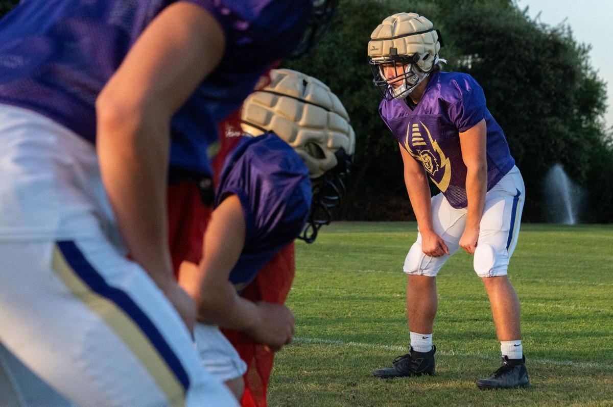 Running back Nathan Zeppieri wears a Guardian Cap over his helmet as he lines up against his teammates during a drill at Bradshaw Christian High School earlier this month.