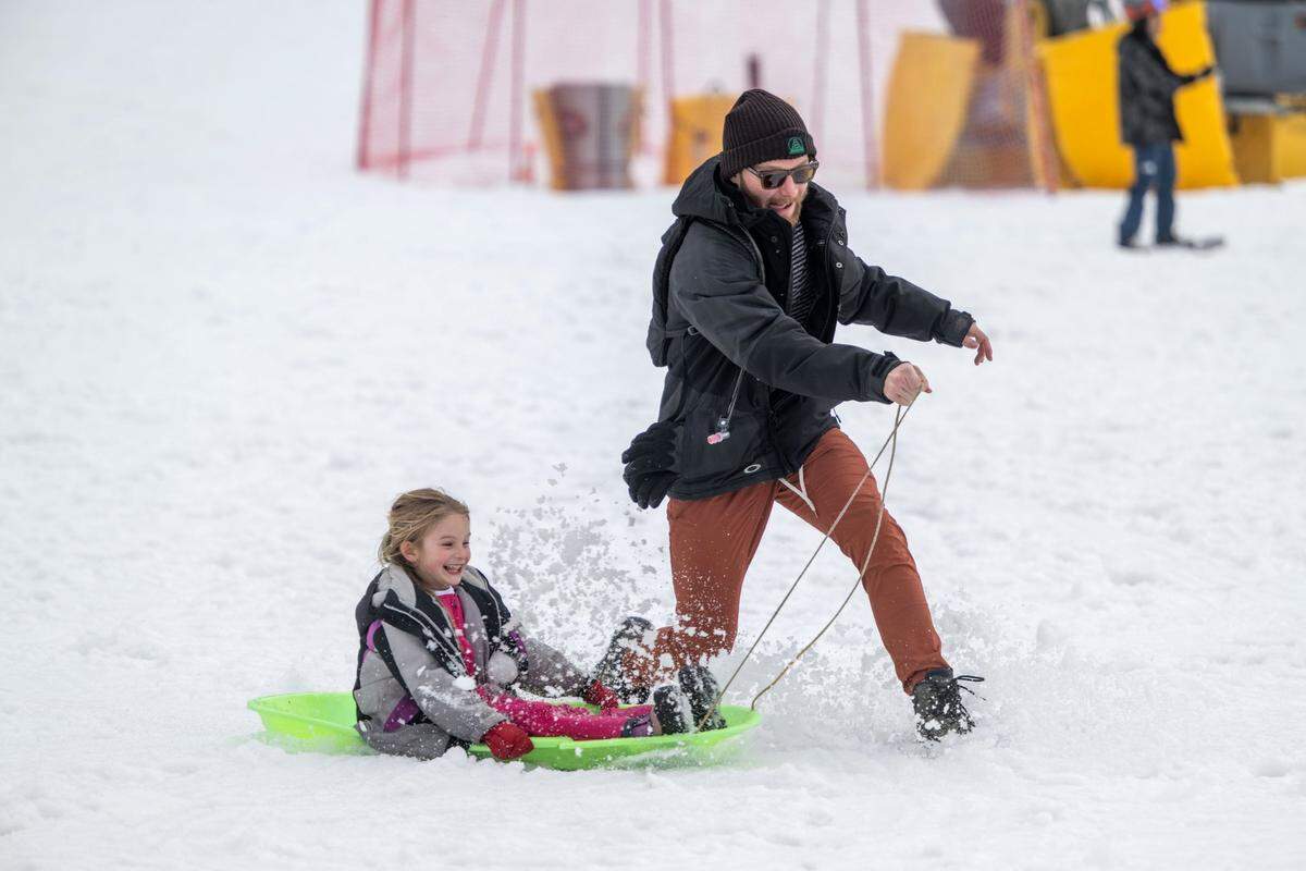Sean Anderson of Oakland pulls his five-year-old daughter Avery on a sled at Palisades Tahoe on Thursday, Dec. 21, 2023. Anderson said that this is the first year the family will spend Christmas in the mountains.
