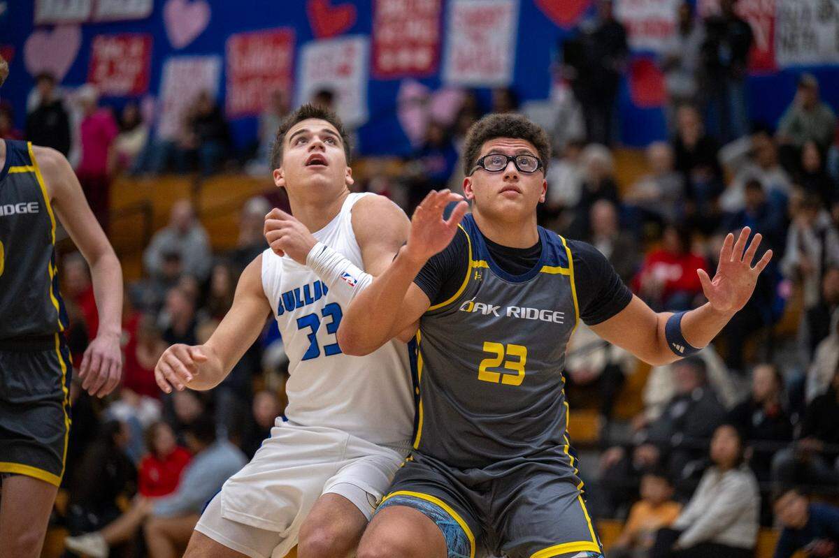 The Folsom Bulldogs’ Ryder Lyons (33) and the Oak Ridge Trojans’ Kaleb Edwards (23) battle for position under the basket in the first half earlier this month in Folsom. Both are five-star football recruits.